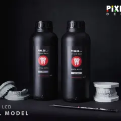 Dwie butelki żywicy UV LCD do tworzenia modeli dentystycznych. Obok stoją modele szczęk.