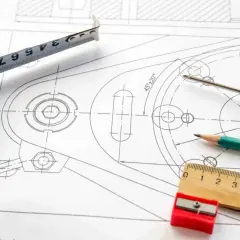 Precyzyjny projekt graficzny z miarką, ołówkiem i śrubokrętem na rysunku technicznym.