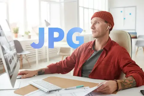 Mężczyzna w czapce i czerwonej koszuli pracuje przy komputerze. Duży napis JPG sugeruje format pliku.