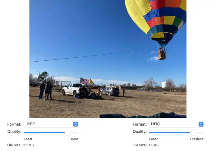 Balon na gorącym powietrzu wznosi się na błękitnym niebie. Na ziemi stoją ludzie, samochody i amerykańska flaga. Obraz porównuje formaty HEIC i JPG.