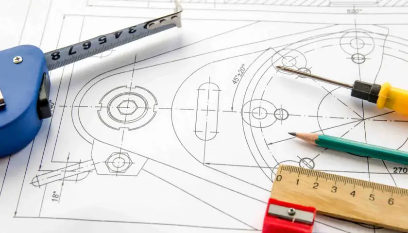 Precyzyjny projekt graficzny z miarką, ołówkiem i śrubokrętem na rysunku technicznym.