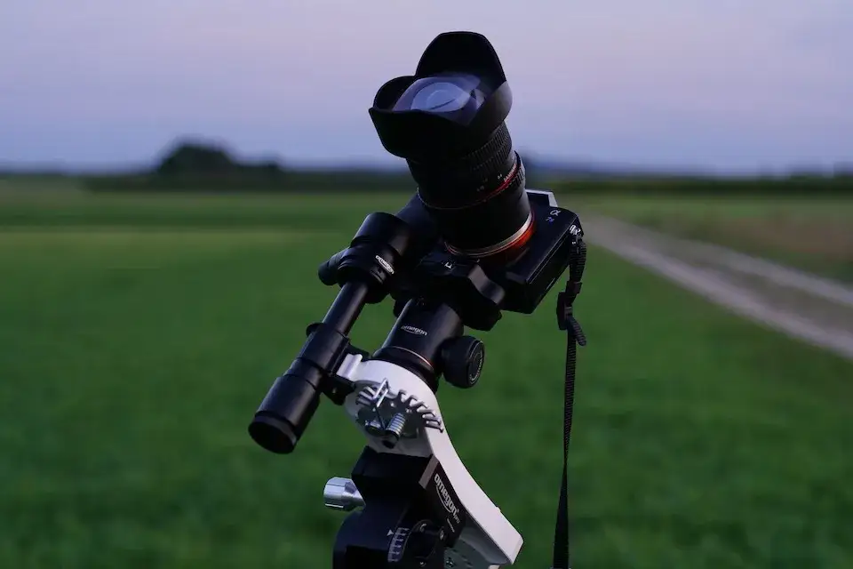 aparat fotograficzny na statywie pod rozgwieżdżonym niebem